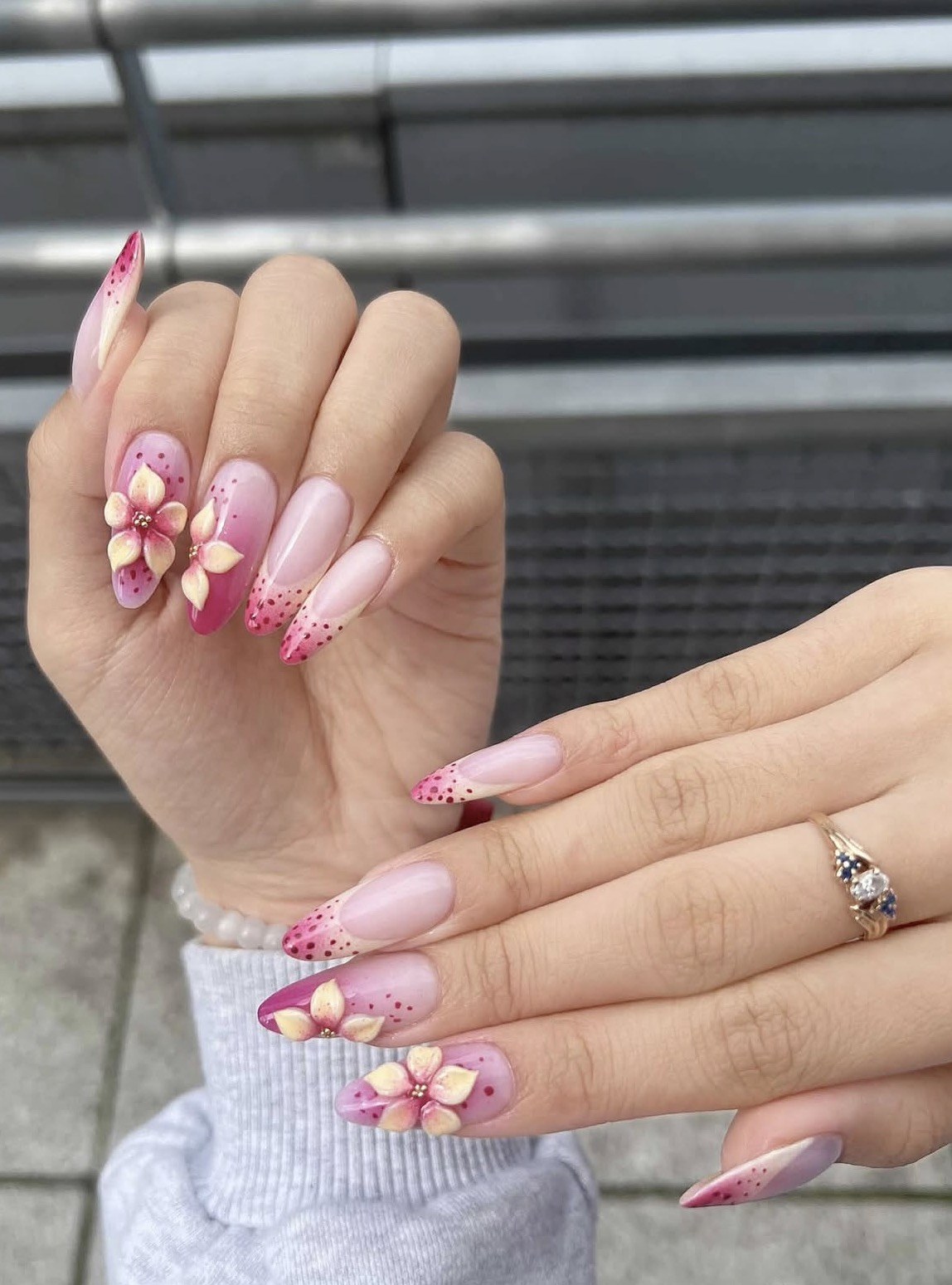 Manicure hybrydowy w odcieniach różu z kwiatowym zdobieniem